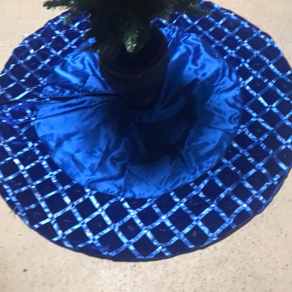 Blue Christmas tree skirt with ribbon and beads. Ribbon is fading in spots.